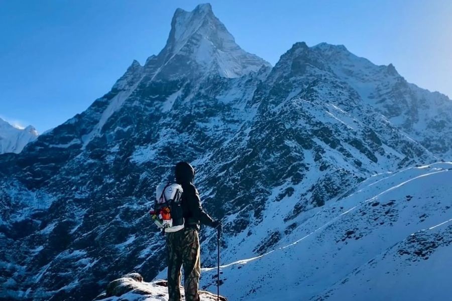 Trekker gazing up at the snow-covered slopes of Machhapuchhre.